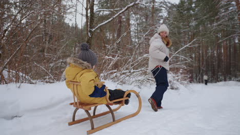 mother-and-little-son-are-spending-time-and-having-fun-in-winter-forest-in-weekend-happy-family